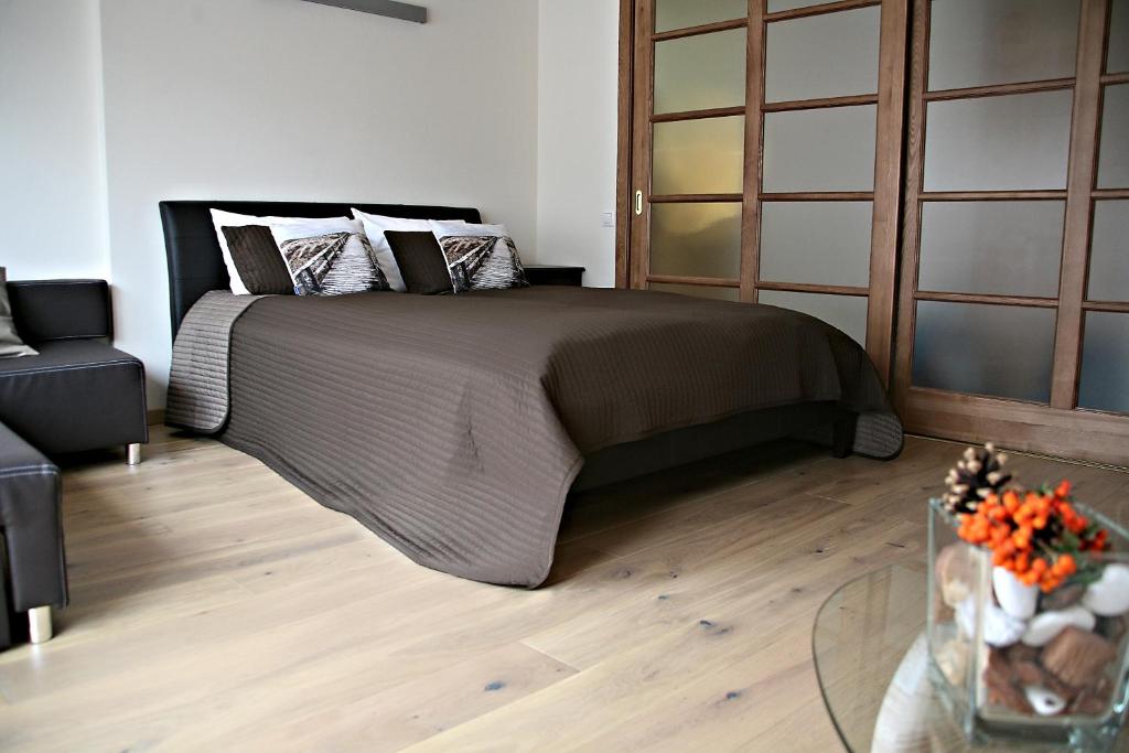 um quarto com uma cama grande e piso em madeira em Holiday Terrace Nida em Nida