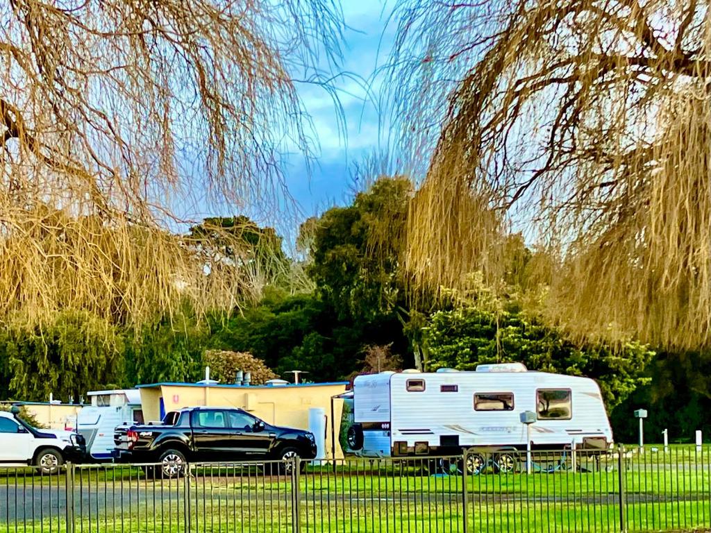 a truck and a camper parked in a parking lot at Lake Colac Holiday Park in Colac