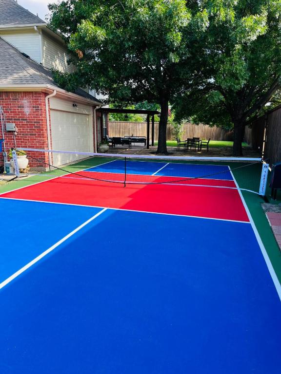 a tennis court with a red and blue at Pickleball , Pool , Bkyd Oasis , Centrally Located in Frisco