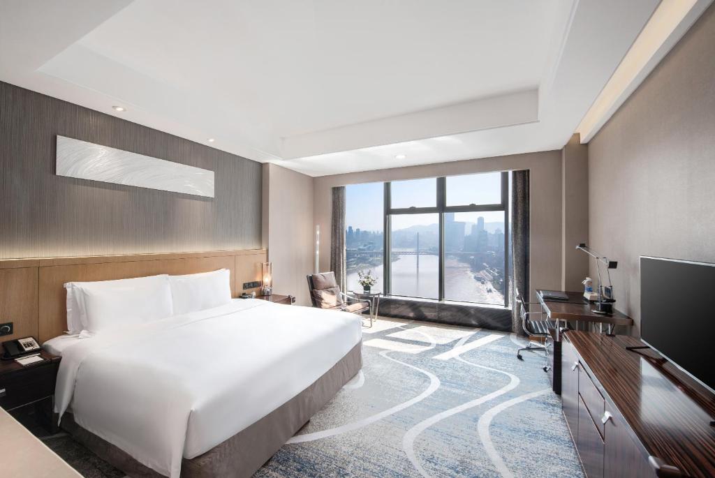 a bedroom with a large bed and a television at C Plaza Hotel in Chongqing