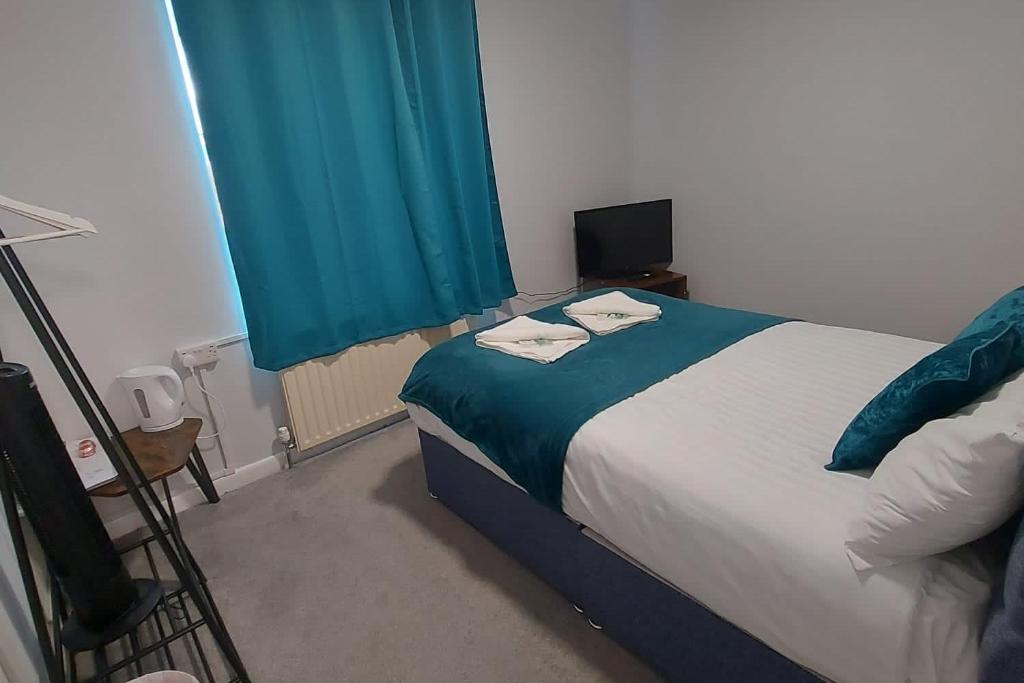 Un dormitorio con una cama y una cortina azul. en Seaside Escape 2-Bed maisonette Flat - Ev22kwh, en Southsea