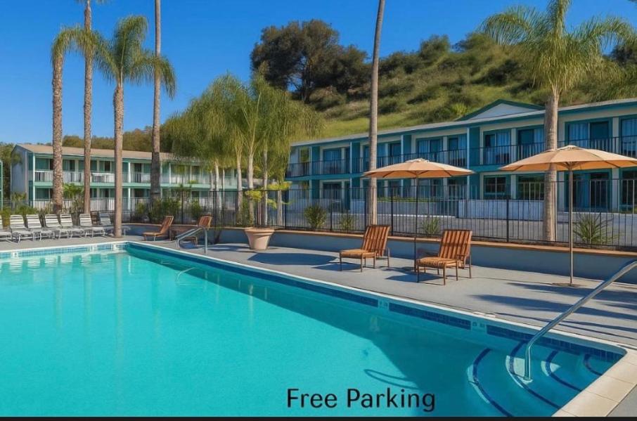 a pool at a resort with chairs and umbrellas at The Atwood Hotel San Diego - SeaWorld/Zoo in San Diego