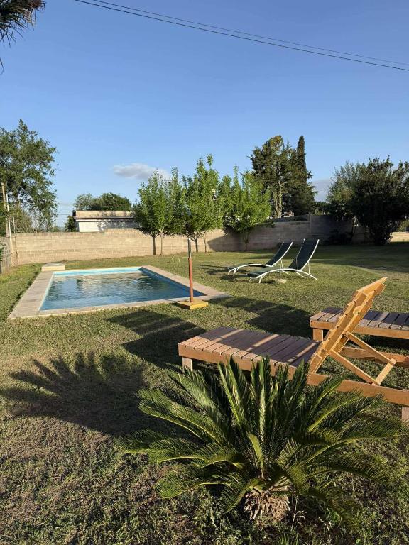 a swimming pool with a bench and a table and chairs at Depto Santa Cruz in Villa Santa Cruz del Lago