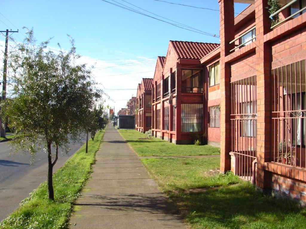an empty street next to a brick building at Apart Hotel Punto Real in Curicó