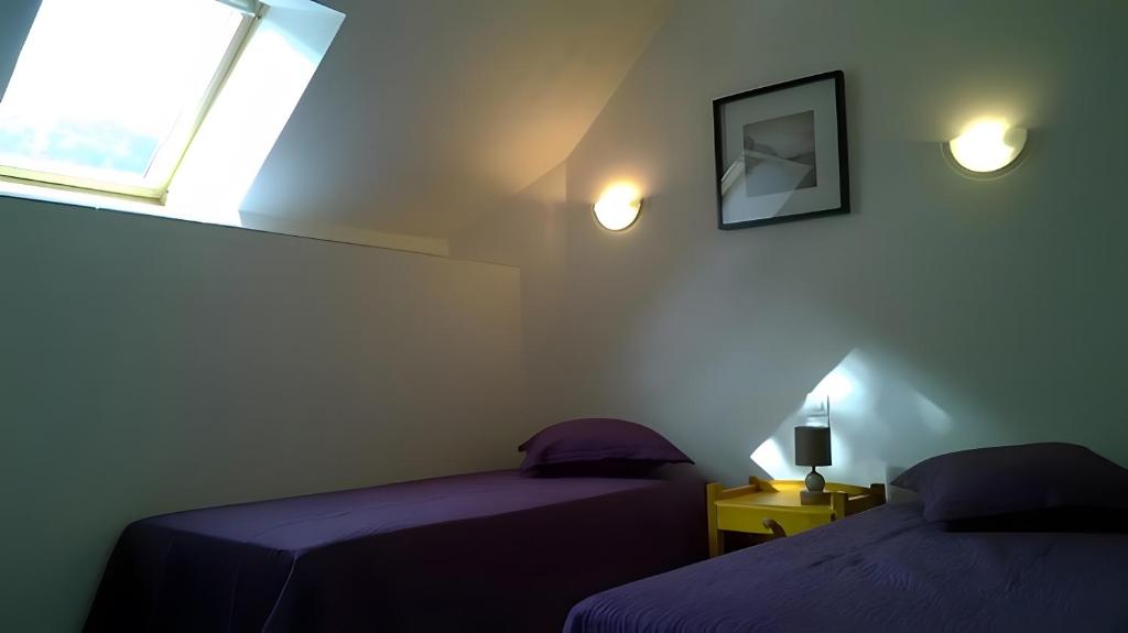 Un dormitorio con dos camas y una ventana. en Gîte À L'orée De Brocéliande 5 pers, en La Saudrais