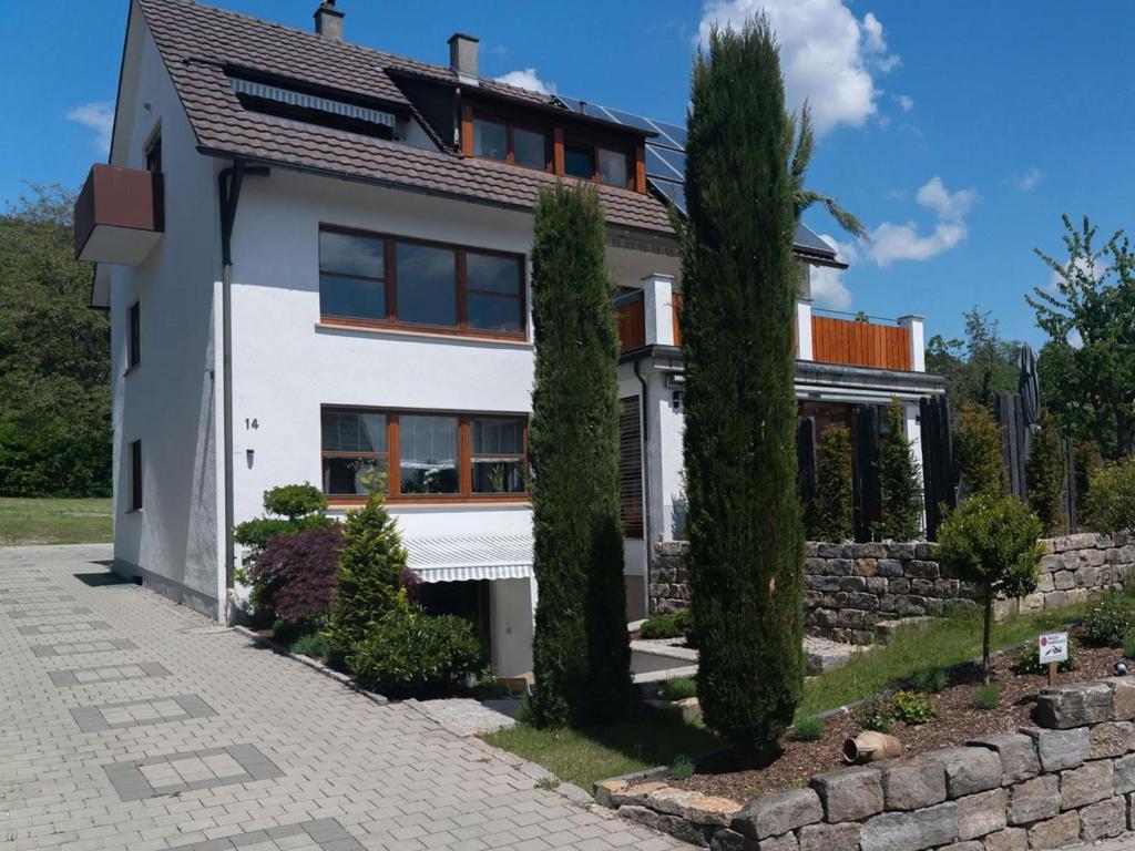 uma casa branca com árvores na frente em Haus Säntisblick em Sipplingen