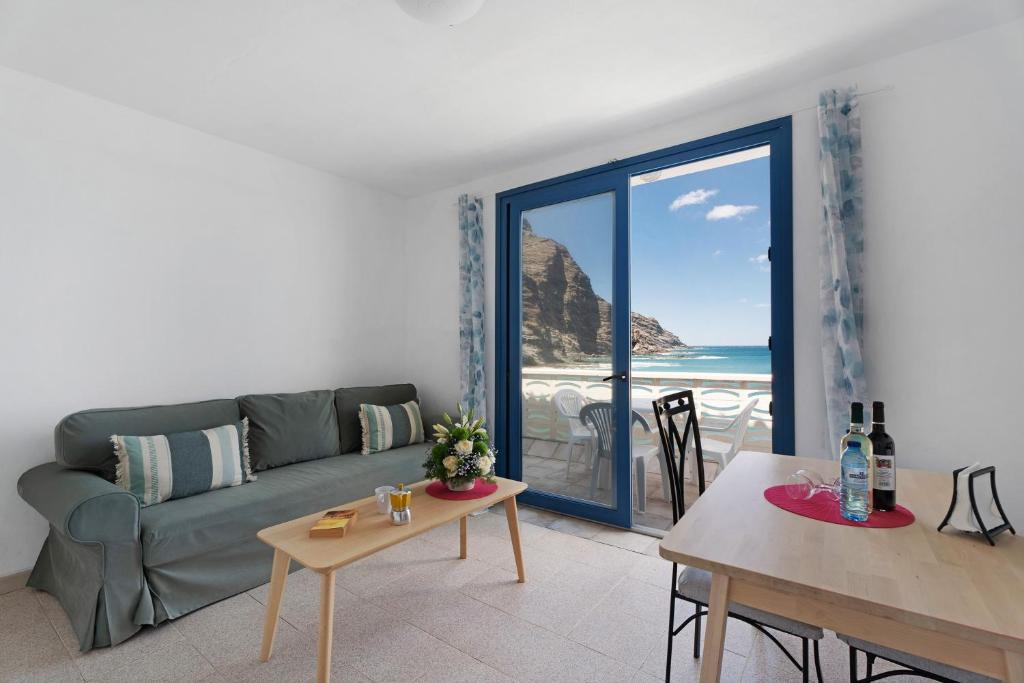バジェエルモソにあるApartamentos Playa Azul - 6のソファがあり海が見えるリビングルーム