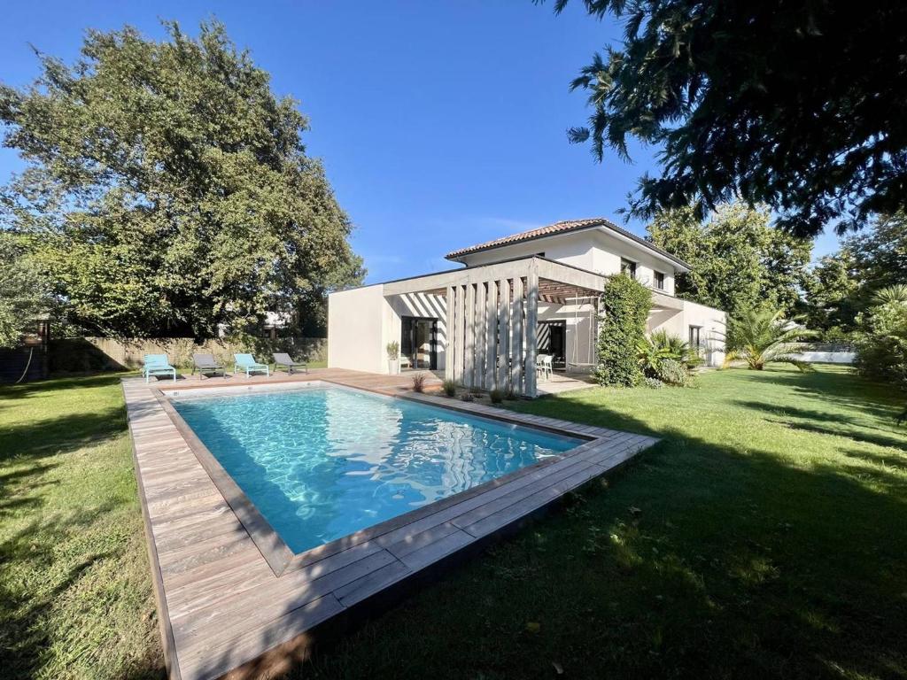 a swimming pool in the yard of a house at Villa 8 pers à Seignosse avec piscine chauffée et clim - FR-1-791-44 in Seignosse