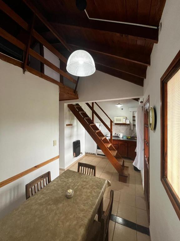 a kitchen and dining room with a table and a staircase at Tu lugar en Santa Clara in Santa Clara del Mar