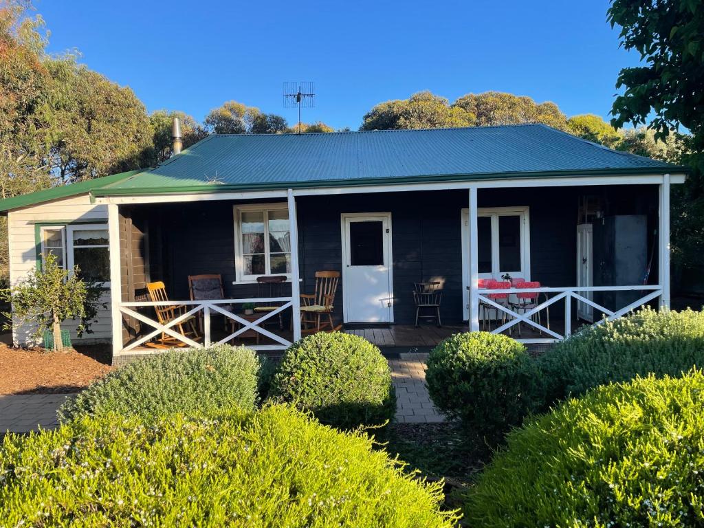 a blue house with a porch and a patio at Swallows Cottage, Margaret River in Witchcliffe