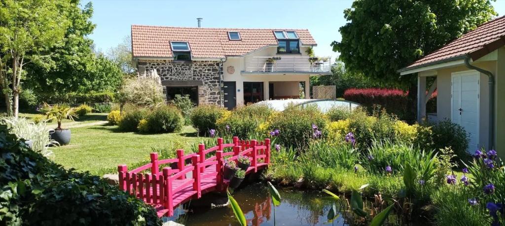 a garden with red benches in front of a house at Gite Des Taravelles in Manzat