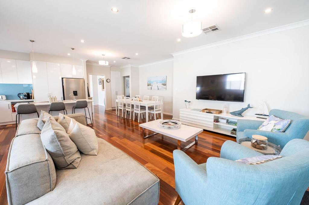 a living room with a couch and chairs and a tv at The Lake House - Spacious Group Haven by the Bay in Victor Harbor