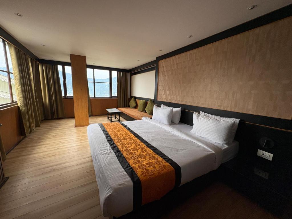 Un dormitorio con una cama grande en una habitación de hotel. en Hotel Mist Tree Mountain, en Gangtok
