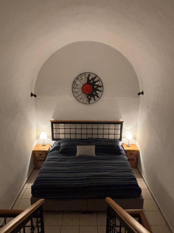 a bedroom with a bed with a clock on the wall at Casa Colibrí Querétaro in Querétaro