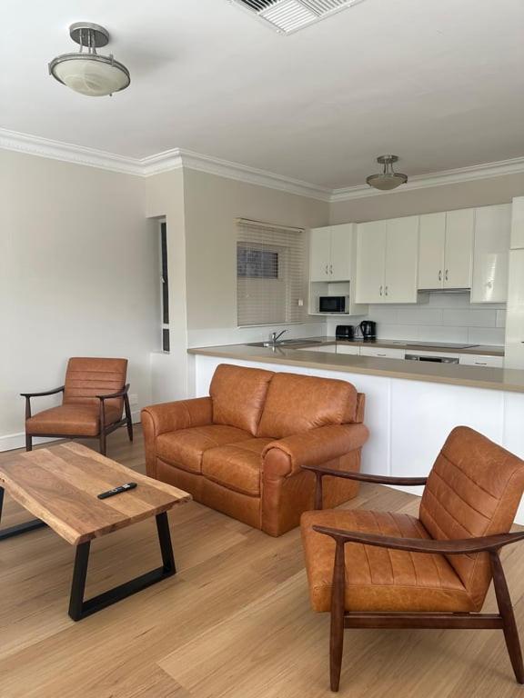 ein Wohnzimmer mit Sofa, Stühlen und einem Tisch in der Unterkunft Riverston Loft in Rockhampton