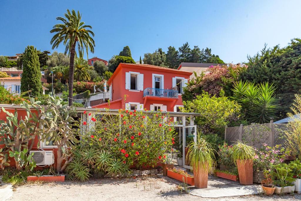a house with a lot of plants in front of it at Hôtel La Villa Patricia - Charme et Tradition in Villefranche-sur-Mer