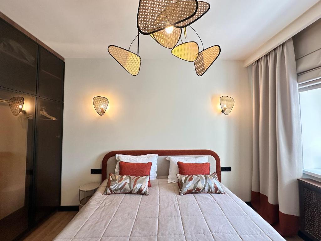 a bedroom with a bed with two pillows on it at Апарт-отель ЗОЛОТОЙ КВАДРАТ premium in Almaty