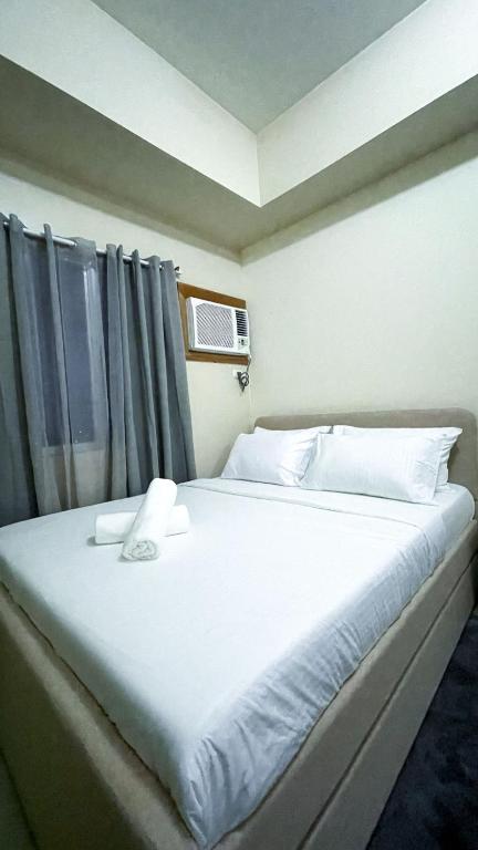 a bedroom with a large white bed with a window at Cozy Modern Studio Overlooking the Skyline in Molo