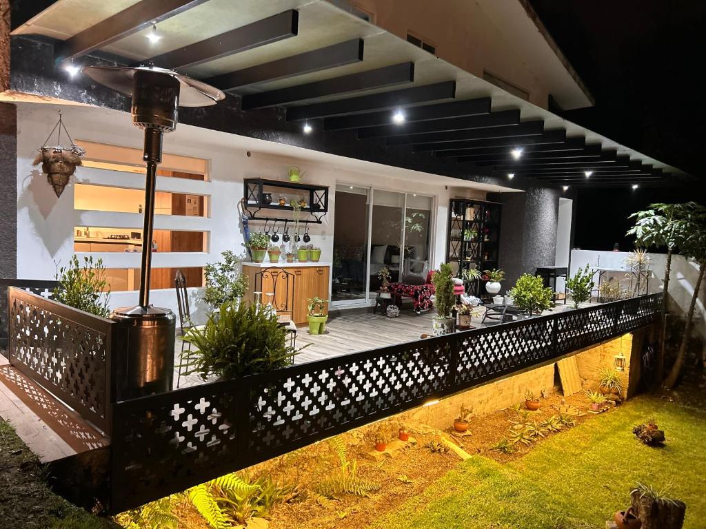 een huis met een veranda met potplanten erop bij Suite de lujo con naturaleza y BBQ cerca de Cuenca in Cuenca