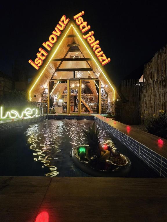 a building with a swimming pool at night at Baku Garden Aframe - Bungalov in Baku