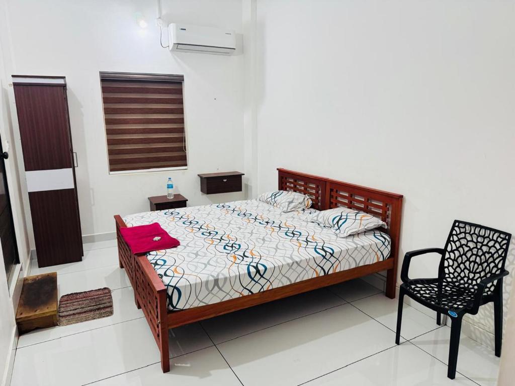 a bedroom with a bed and a chair in it at Barkka in Ponnāni