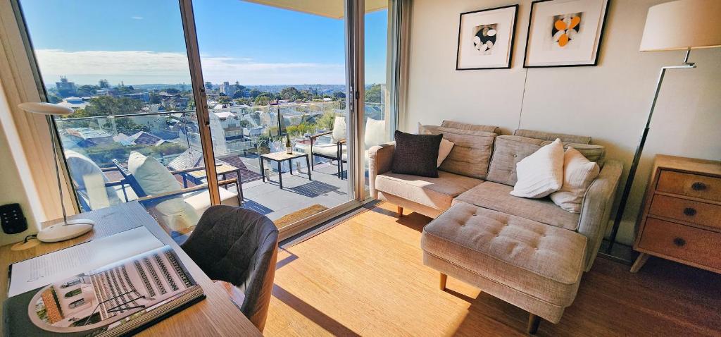 a living room with a couch and chairs and a balcony at Sweeping Harbour & Ocean Views Over Sydney's East in Sydney