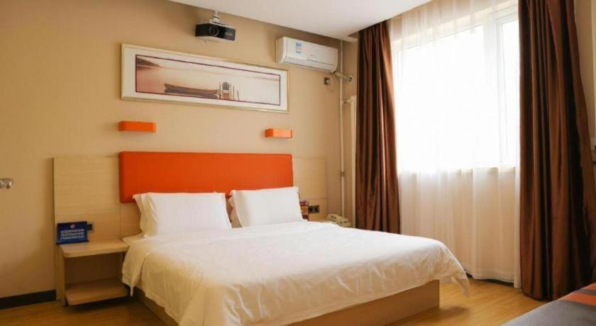 北京市にある7 Days Premium Beijing Dabaotai Metro Station Luhua Roadのベッドルーム1室(オレンジ色のヘッドボードと窓付)