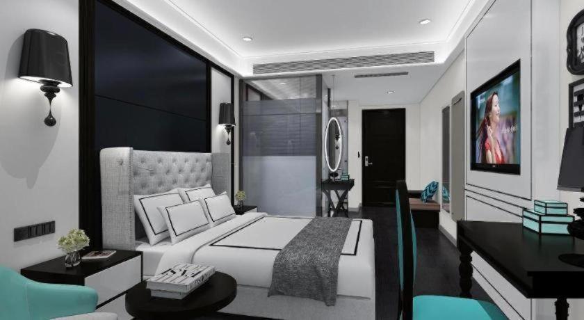 une chambre avec un grand lit blanc et un bureau dans l'établissement Xana Hotelle Shijiazhuang Zhongchu Plaza Shizhuang Metro Station, à Shijiazhuang