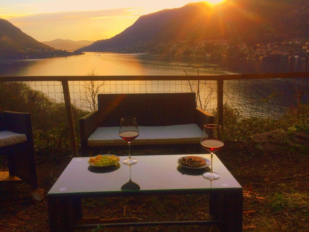 Pognana LarioにあるApartment Casa Dono Il lagoの川の景色を望むテーブルの上にワイン2杯