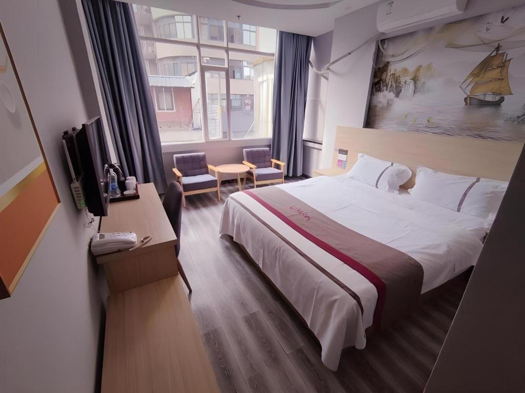 une chambre d'hôtel avec un grand lit et une télévision dans l'établissement Thank Inn Hotel Sichuan Zigong Ziliujing District Wuxing Street, à Zigong