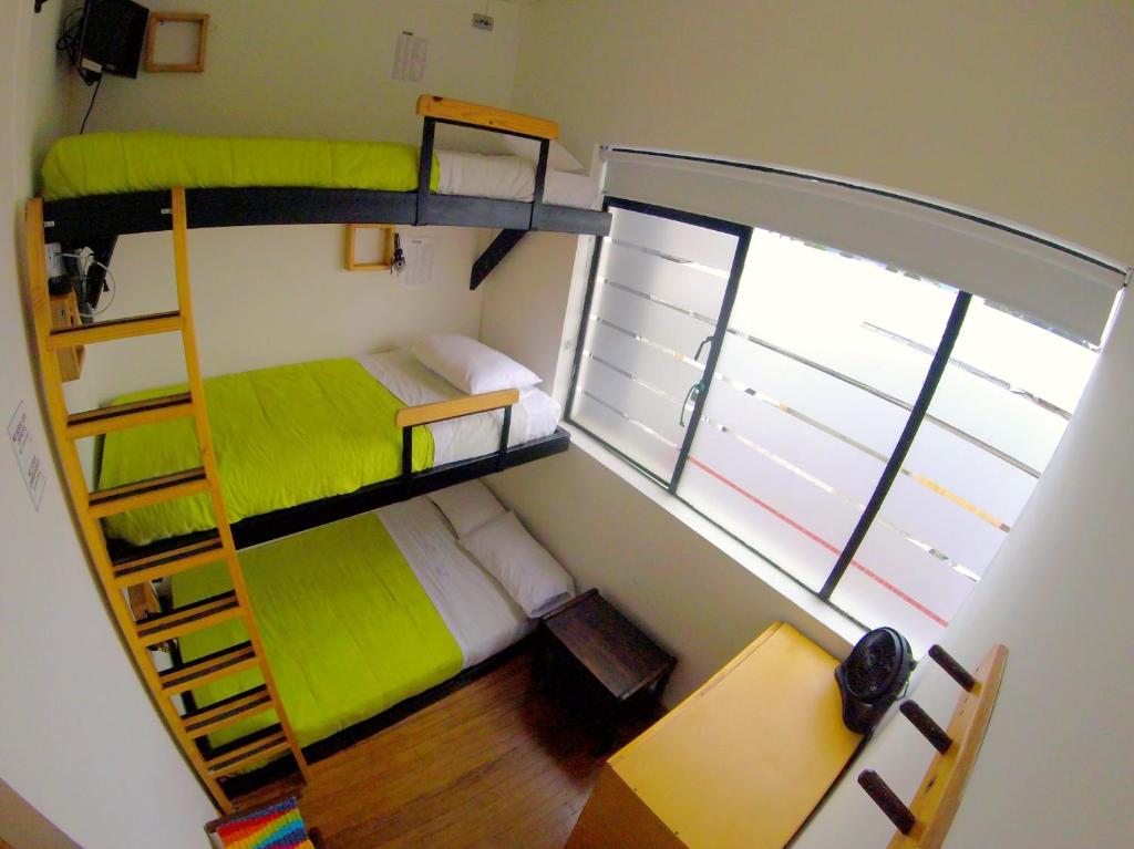 a small room with two bunk beds and a window at Hostal de la 57 in Manizales