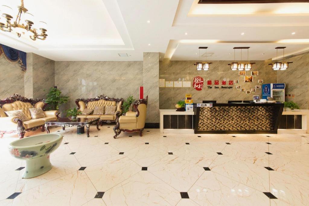 a lobby with a waiting room with chairs and a counter at PAI Hotels Shijiazhuang Zhengding Gucheng in Zhengding
