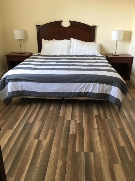 een slaapkamer met een bed en houten vloeren bij Miami Coral Gables Apartment in Miami