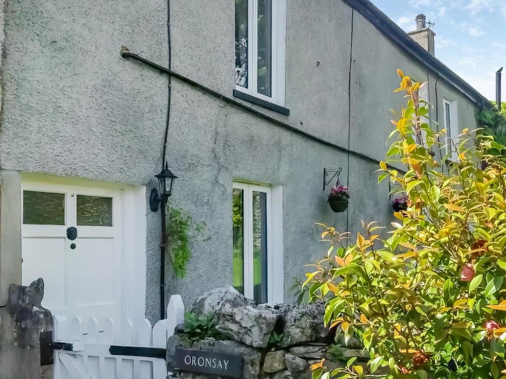 a house with a white door and some plants at Oronsay Cottage in Great Urswick