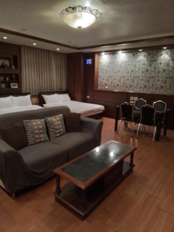 a living room with a couch and a bed and a table at 社長的家 in Luodong