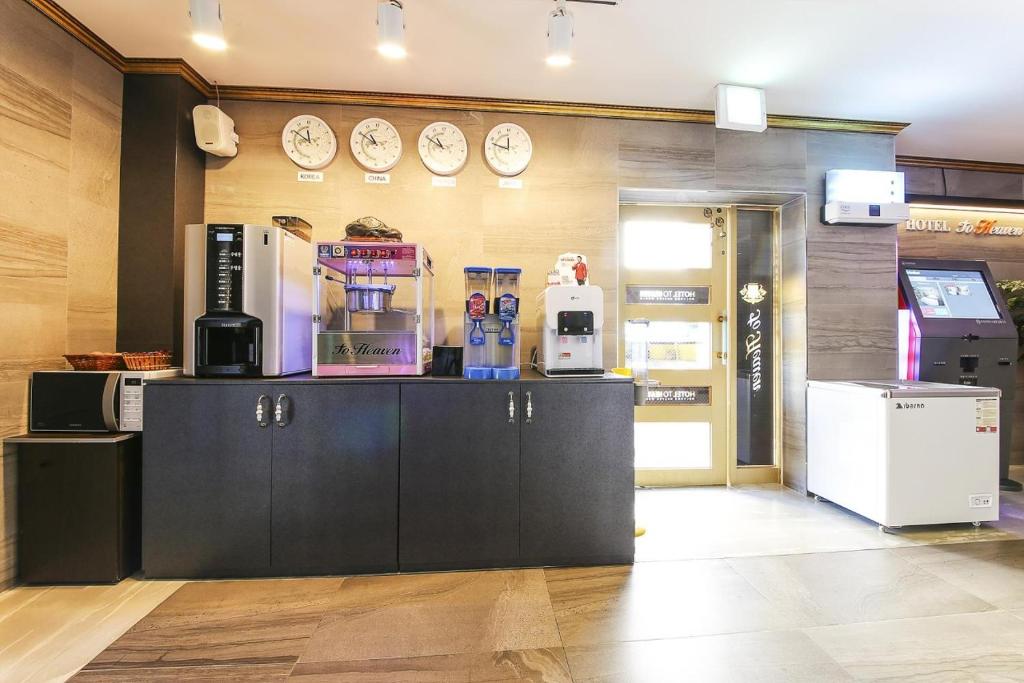 una cafetería con relojes en la pared en 전주 투헤븐, en Haga-ri