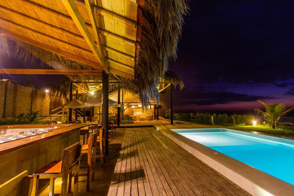 un complejo con piscina por la noche en Hoja de Palma Bungalows, en Canoas de Punta Sal
