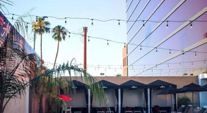 a patio with tables and umbrellas and palm trees at Ahern Hotel and Event Center in Las Vegas