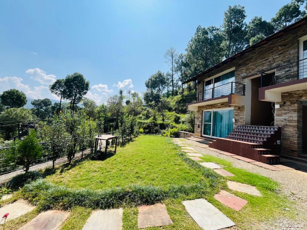 a house with a grassy yard next to a building at Villa Himalayan Trove in Jāmb