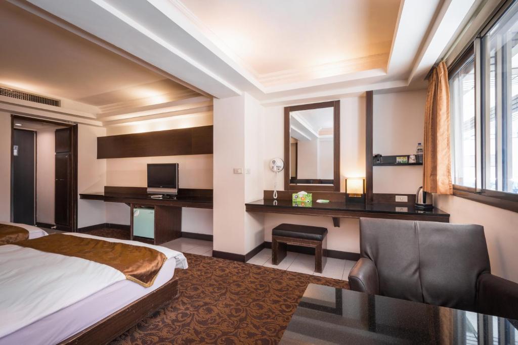 a hotel room with a bed and a desk at The Enterpriser Hotel in Taichung