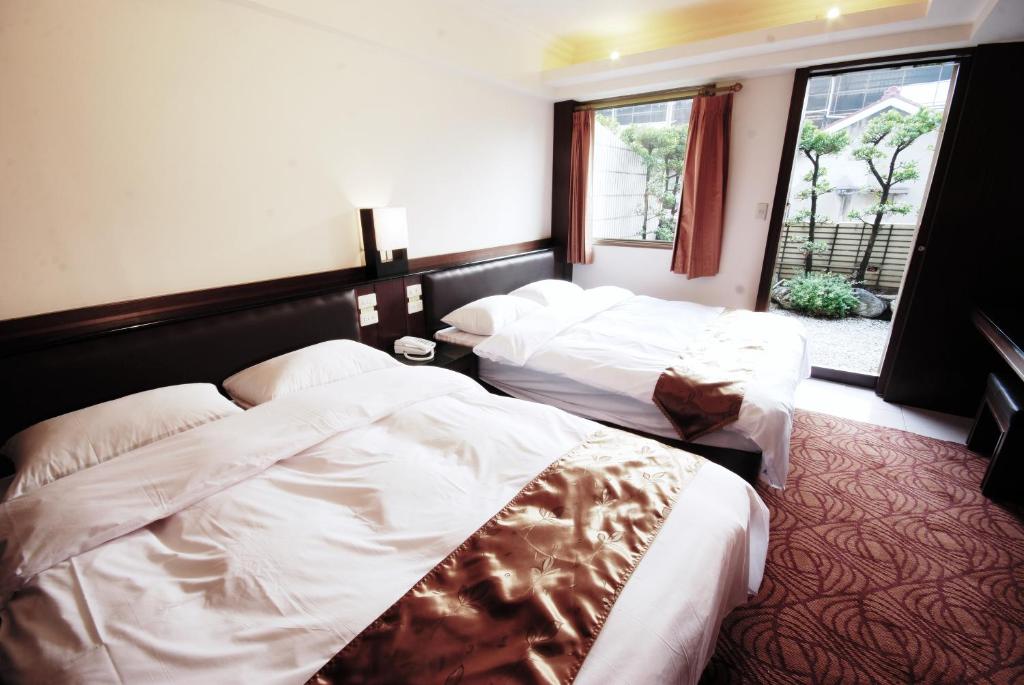 a hotel room with two beds and a window at The Enterpriser Hotel in Taichung