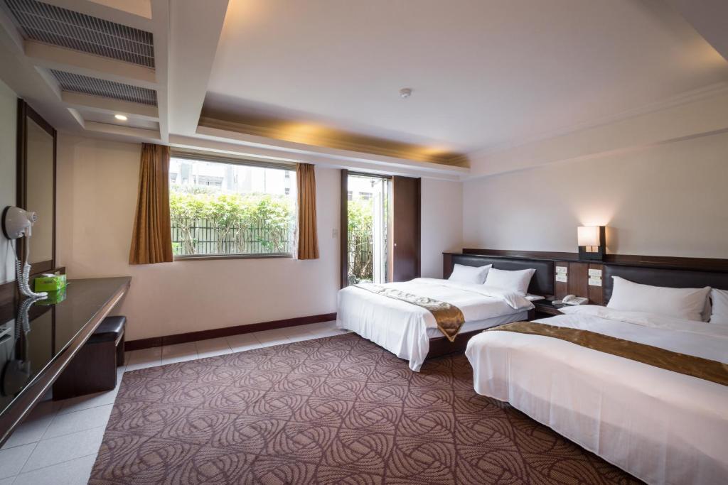 a hotel room with two beds and a window at The Enterpriser Hotel in Taichung