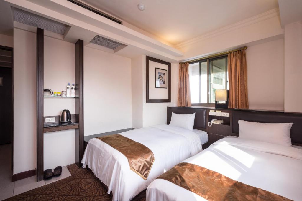 a hotel room with two beds and a window at The Enterpriser Hotel in Taichung
