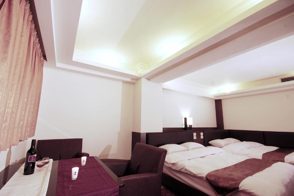 a bedroom with a bed and a chair and a table at The Enterpriser Hotel in Taichung