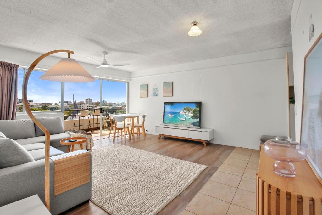 a living room with a couch and a tv at Kailoha Unit 8, 27 Canberra Tce, Kings Beach in Caloundra