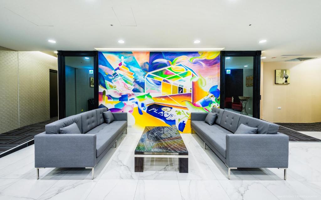 a lobby with two couches and a colorful wall at Place‧X Hotel in Taipei