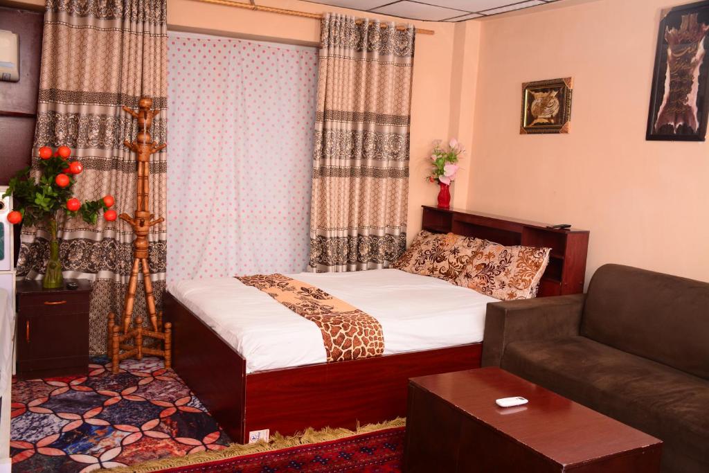 a small bedroom with a bed and a couch at Kabul Blue Star Guest House Number 2 in Kabul