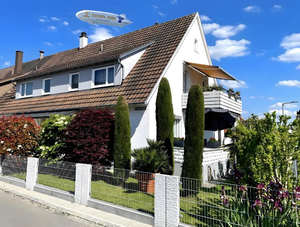 un avion survole une maison avec des arbres dans l'établissement Ferienhaus Jäger, à Friedrichshafen