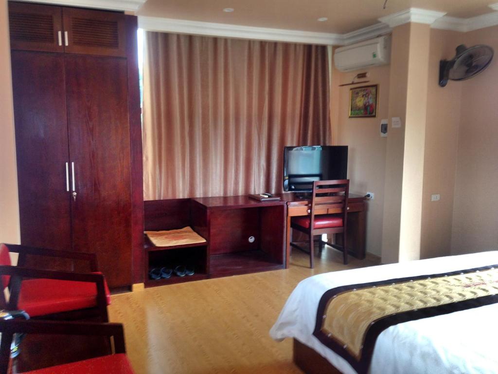 a hotel room with a bedroom with a desk and a bed at Hong Ky Boutique Hotel in Diện Biên Phủ