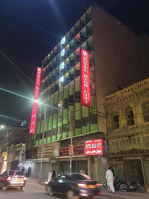 a building with red signs on the side of it at High City Hotel in Dargai